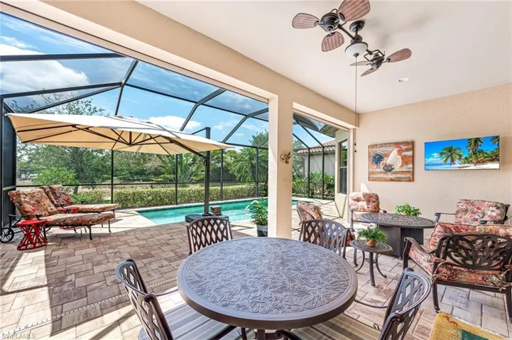 View of patio featuring a lanai, an outdoor pool, ceiling fan, and an outdoor living space
