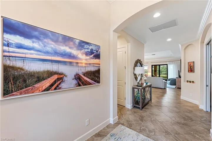 Hall featuring visible vents, baseboards, ornamental molding, and a water view