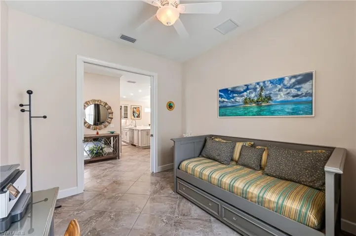 Living room featuring baseboards, visible vents, marble finish floor, and ceiling fan