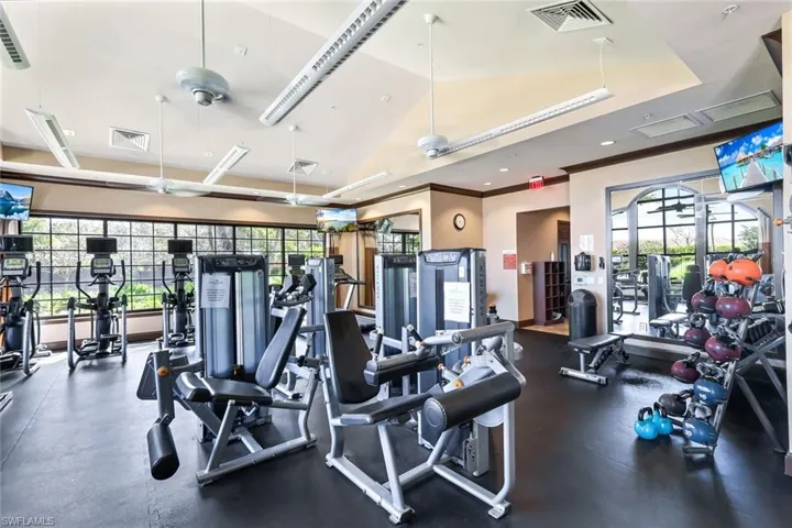 Workout area with a raised ceiling, visible vents, and a wealth of natural light