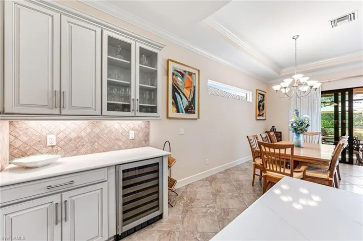 Dining room featuring an inviting chandelier, beverage cooler, a healthy amount of sunlight, and visible vents