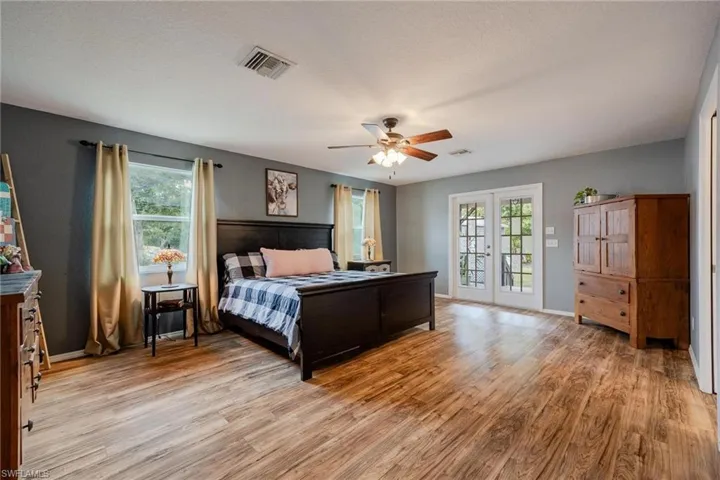 Primary Bedroom has lots of lovely natural light and French doors leading out to the grand back porch over looking the lush property to the rear.