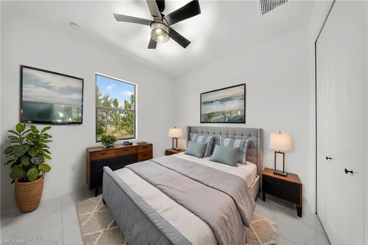 Windowed bedroom featuring ceiling fan, recessed lighting, and tile flooring