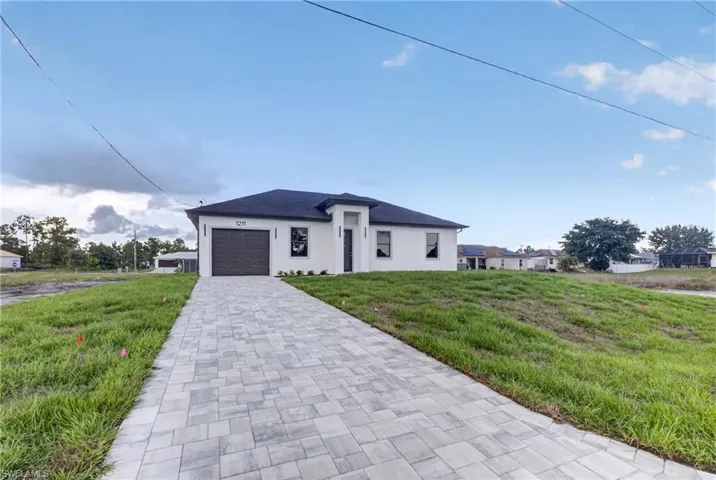 Contemporary single-story residence with a dark roof and white exterior
