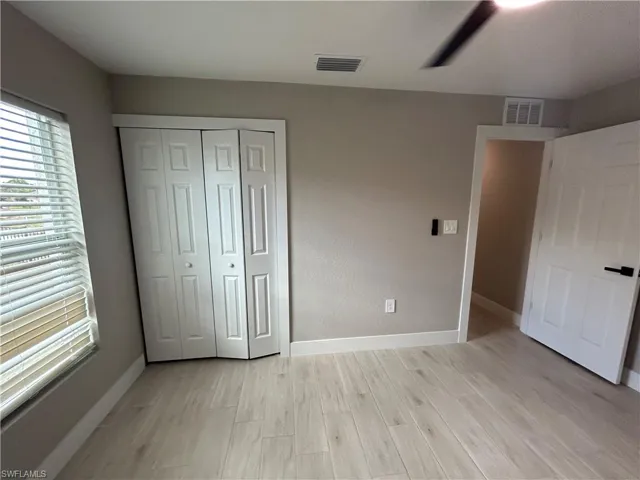 Unfurnished bedroom featuring light wood-type flooring and a closet