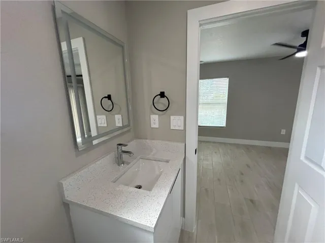 Bathroom featuring vanity, light wood-style flooring, and ceiling fan