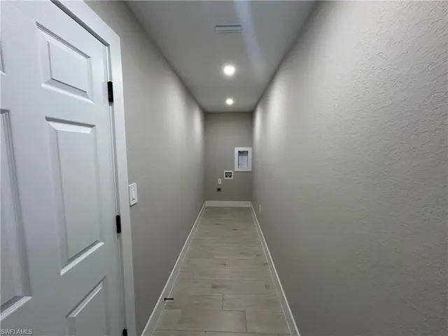 Laundry room with electric dryer hookup, recessed lighting, hookup for a washing machine, and a textured wall