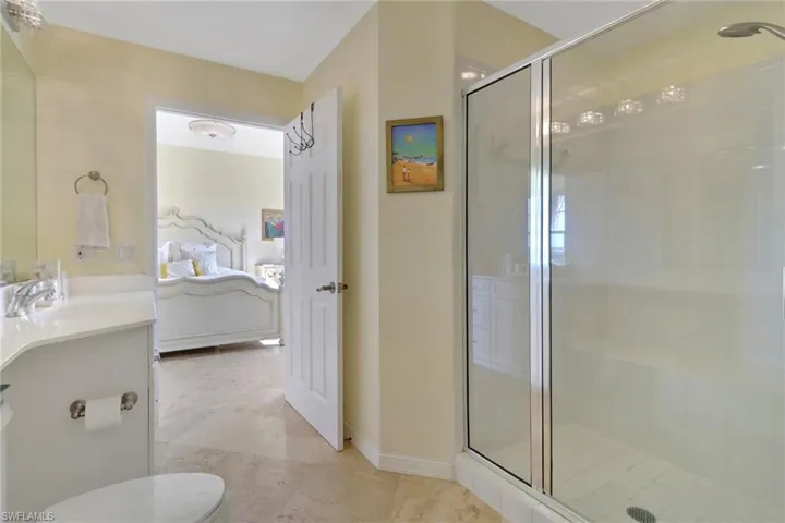 Bathroom featuring walk in shower, vanity, toilet, and tile patterned floors