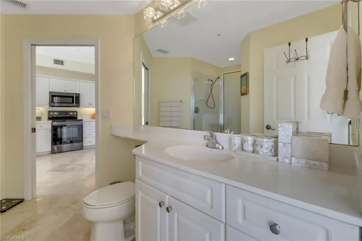 Bathroom with vanity, toilet, and an enclosed shower