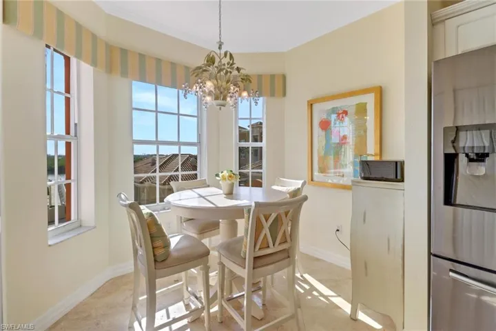 Tiled dining space with ornamental molding and an inviting chandelier