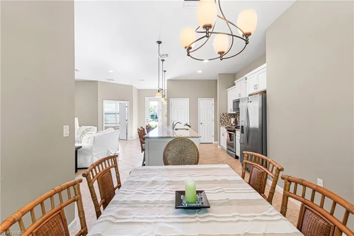 Dining area with light tile patterned floors, a chandelier, and recessed lighting