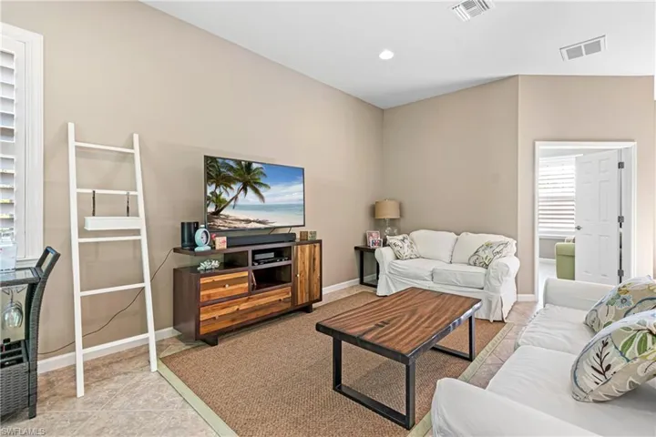 Living room with light tile patterned floors and recessed lighting