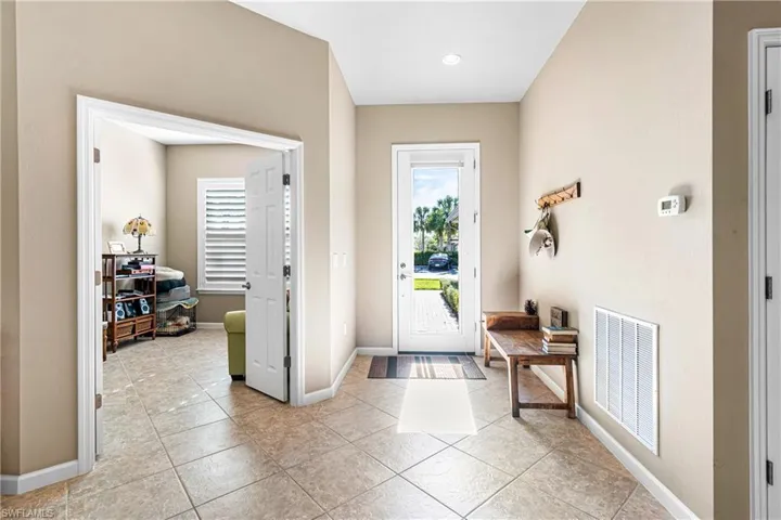 Foyer featuring light tile patterned floors and baseboards