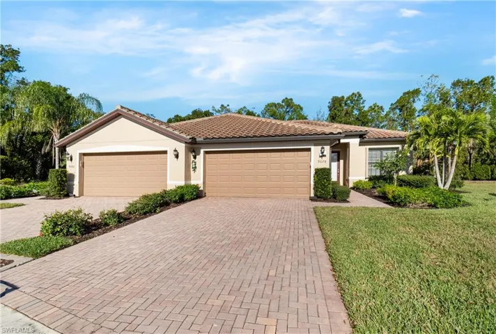 View of front of house featuring stucco siding, decorative driveway, a garage, and a front yard
