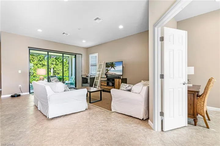 Living room with recessed lighting and light tile patterned floors