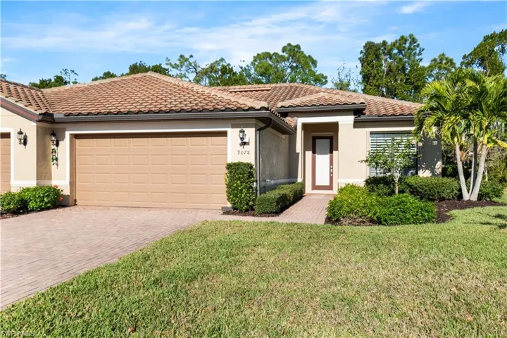 Mediterranean / spanish home with stucco siding, a garage, decorative driveway, and a tiled roof