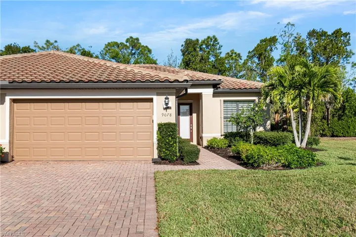 Mediterranean / spanish home featuring decorative driveway, a tile roof, stucco siding, a front lawn, and a garage