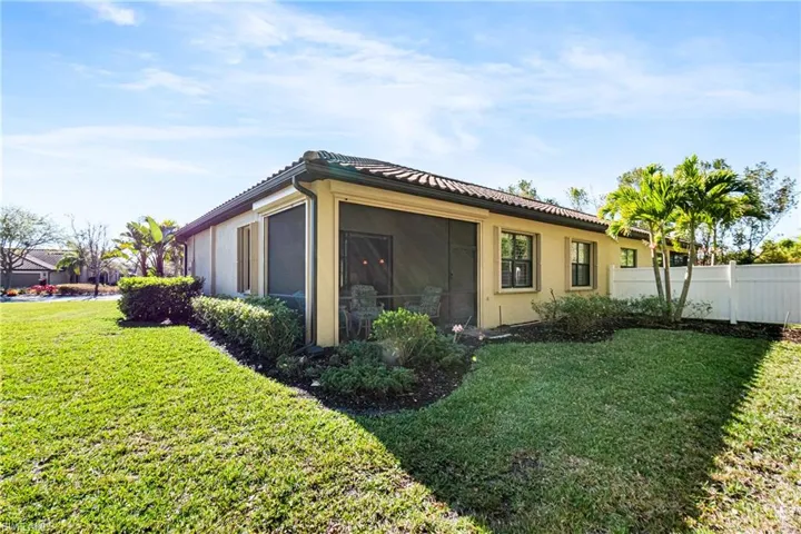 View of side of property with stucco siding, a tiled roof, and a sunroom