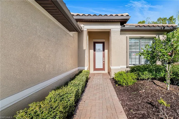 Property entrance with stucco siding and a tiled roof