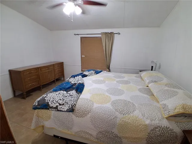 Tiled bedroom with a ceiling fan