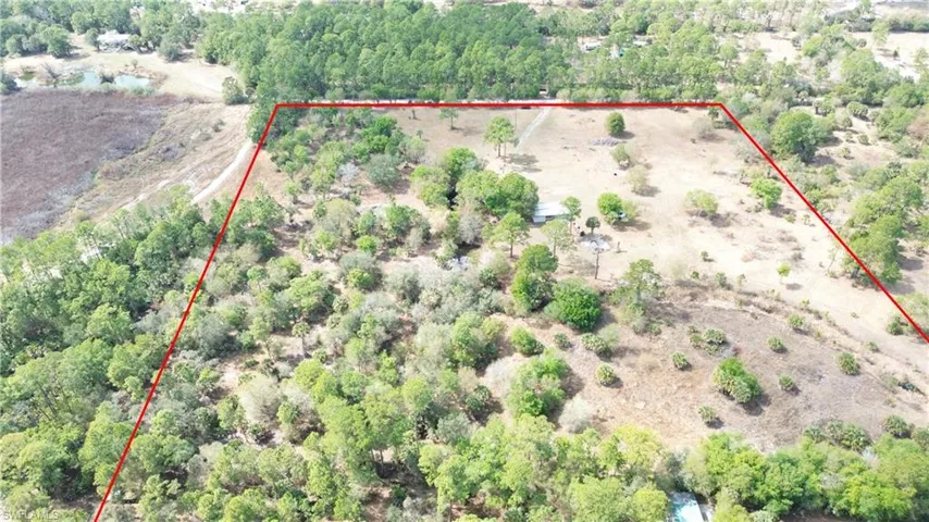 Aerial view of sparsely populated area featuring property parcel outlined