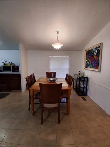 Dining room featuring light tile patterned flooring and lofted ceiling