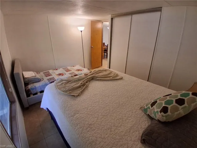Tiled bedroom featuring a decorative wall and a closet