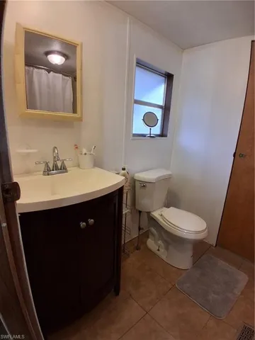 Full bathroom with vanity, a shower with shower curtain, and light tile patterned flooring