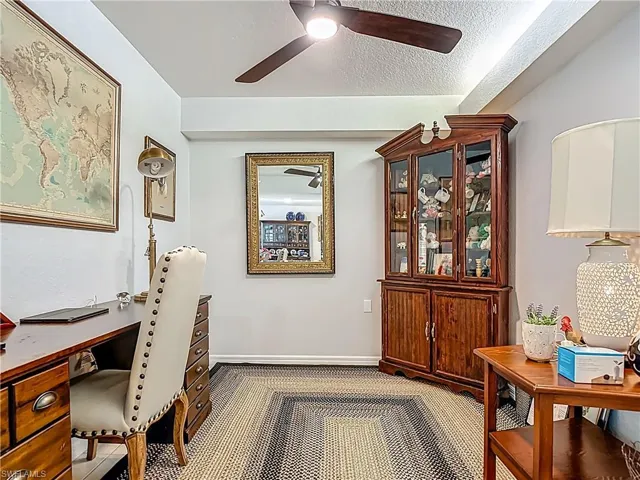 Carpeted home office with a textured ceiling