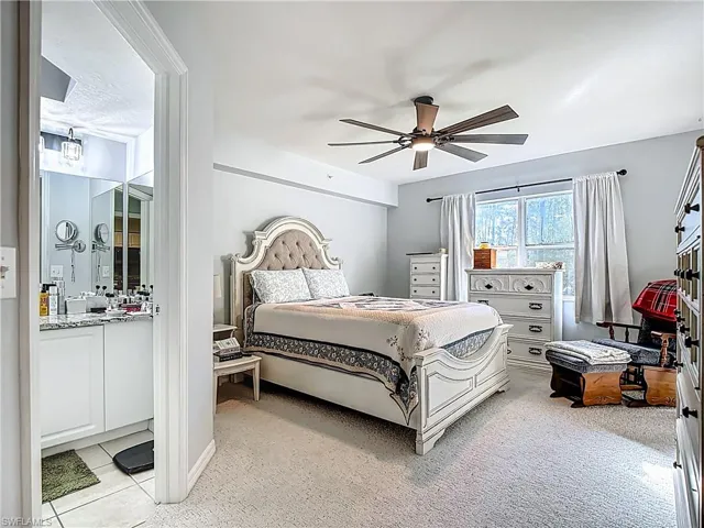 Bedroom with ceiling fan and light carpet