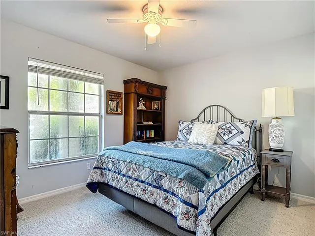 Bedroom with ceiling fan and light carpet