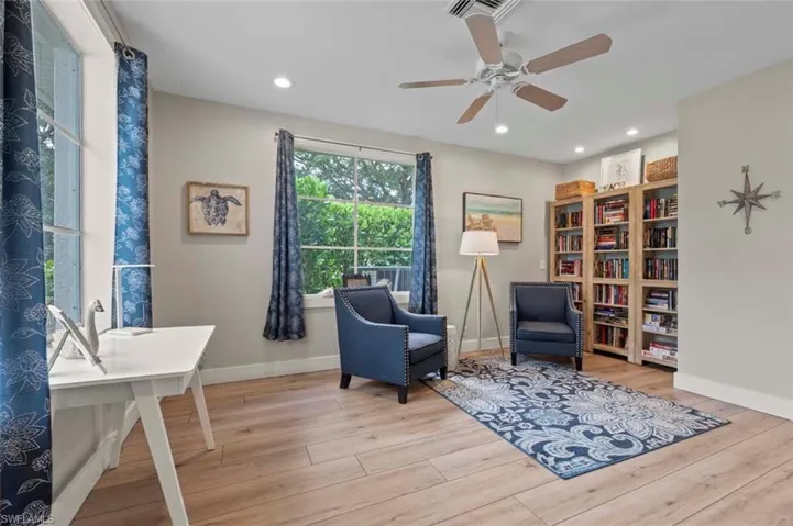 Living area featuring light wood-type flooring, a ceiling fan, and recessed lighting