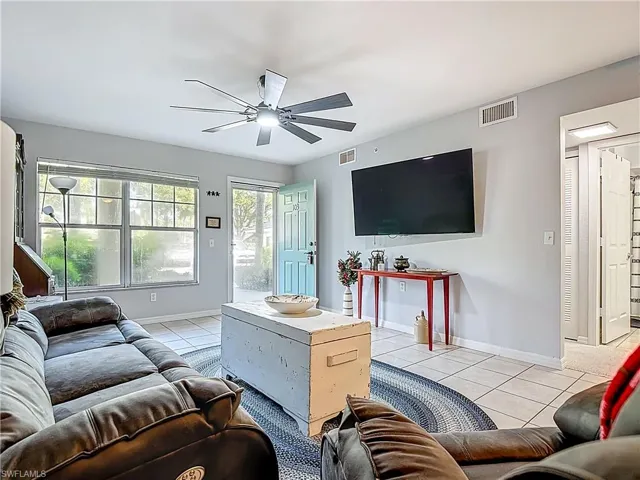 Living room featuring light tile patterned flooring and ceiling fan