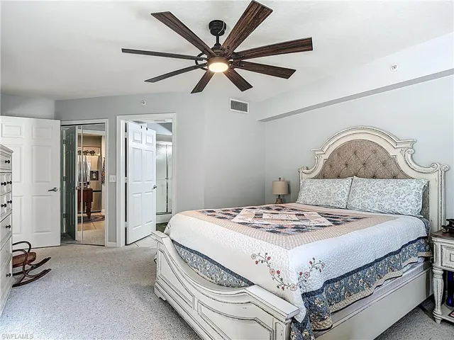 Carpeted bedroom featuring ceiling fan and high end fridge