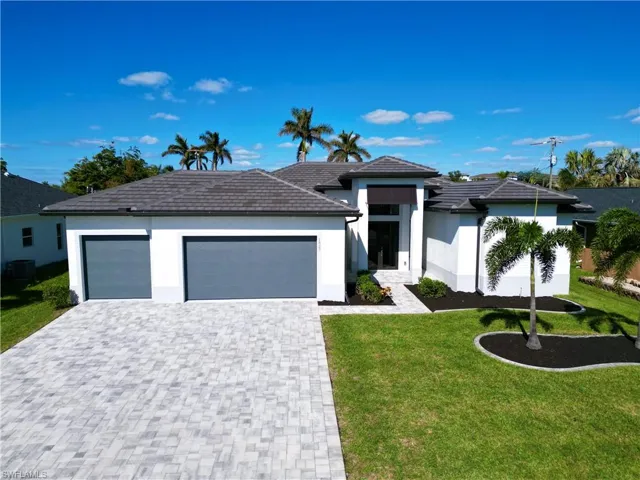 View of front of home with a front yard, a garage, and central air condition unit