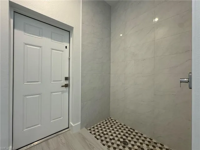 Bathroom featuring a tile shower and wood-type flooring