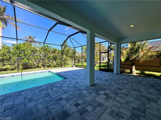 View of swimming pool featuring a lanai and a patio
