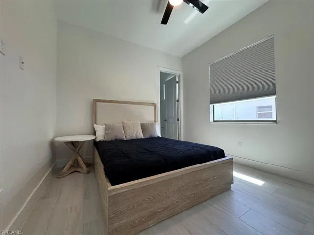 Bedroom featuring wood finished floors, a ceiling fan, and baseboards