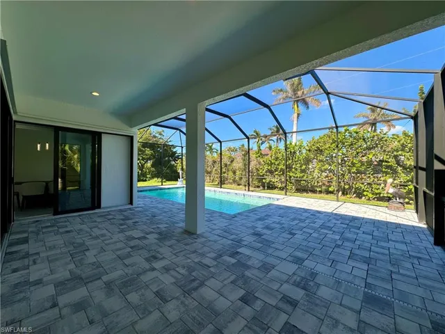 View of pool with a patio and glass enclosure