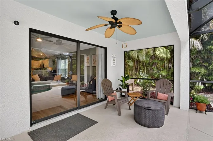 If you want to escape from the sun, we have a covered sitting area that is also screened patio with a light-colored concrete surface, ceiling fan with wicker blades, and a light blue ceiling