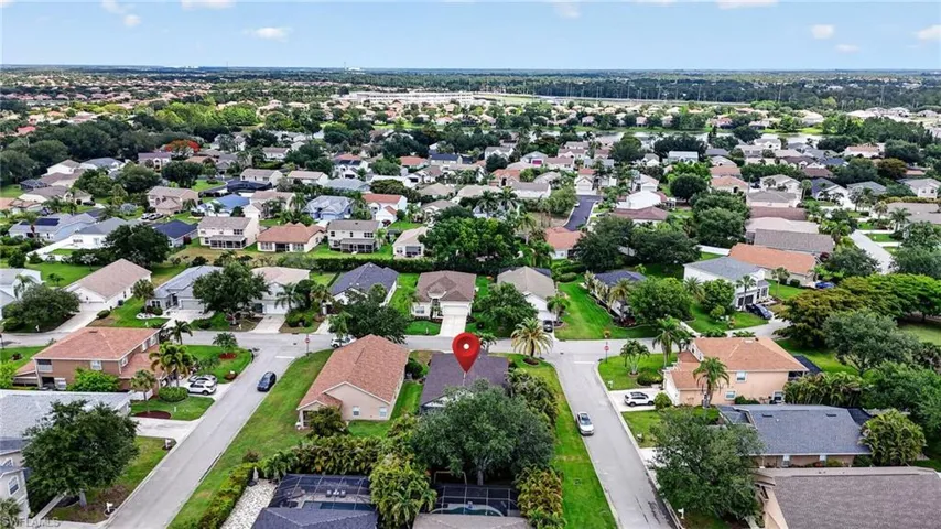 Aerial view showcasing a residential neighborhood with a mix of single-story and two-story homes, mature landscaping, and paved streets