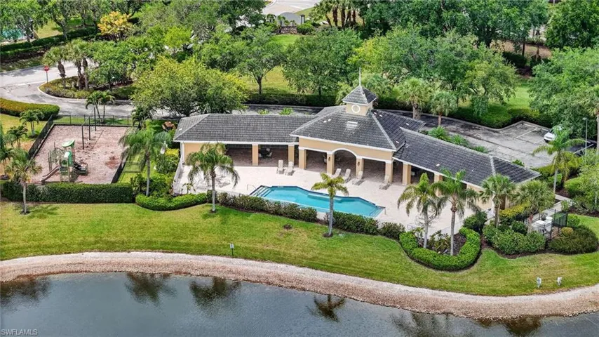 Community pool, resort-style pool area featuring a covered patio, paved sundeck, and lush tropical landscaping