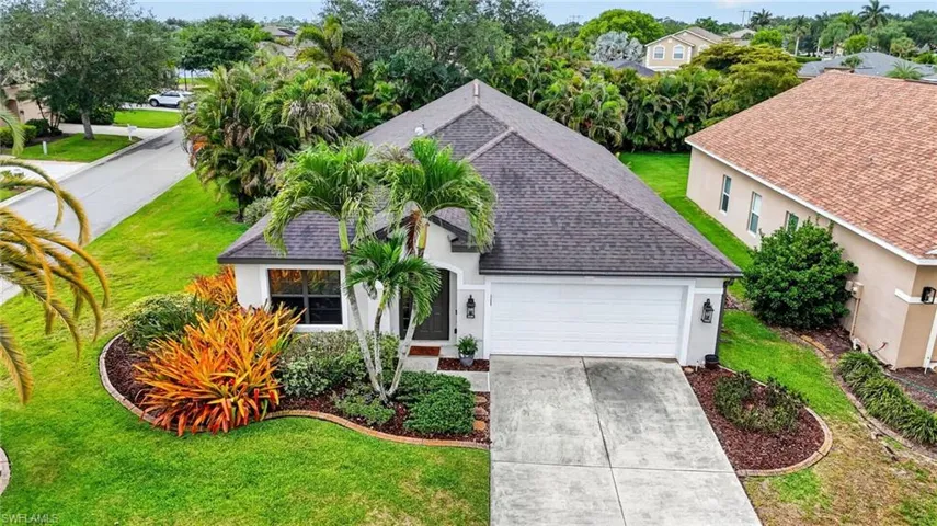 Corner lot that provides privacy for single-story residence featuring a dark shingle roof and a two-car garage