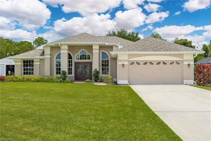 View of front of property with a garage and a front yard