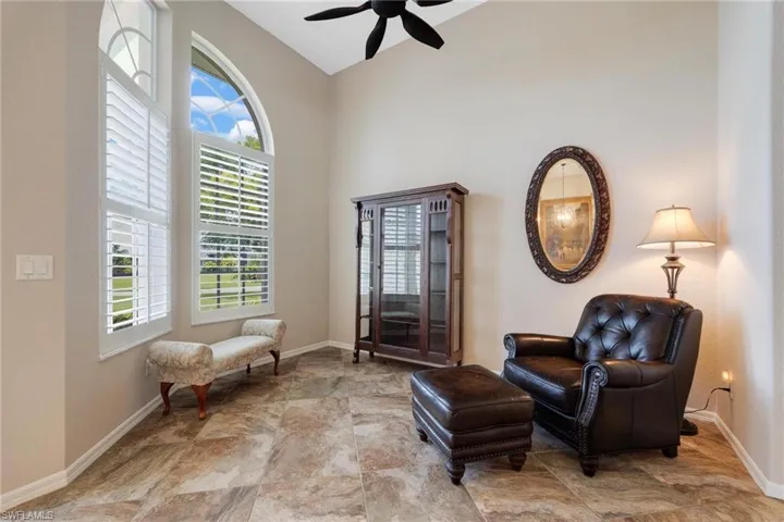 Sitting room with ceiling fan and tile floors