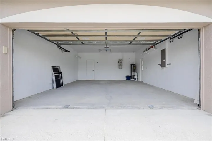 Garage featuring a garage door opener and water heater