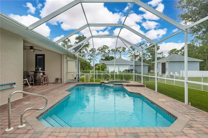 View of pool with a lanai, an in ground hot tub, a yard, a patio area, and ceiling fan