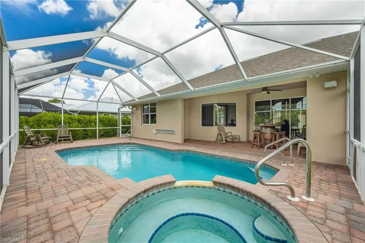 View of pool with ceiling fan, an in ground hot tub, a lanai, and a patio area
