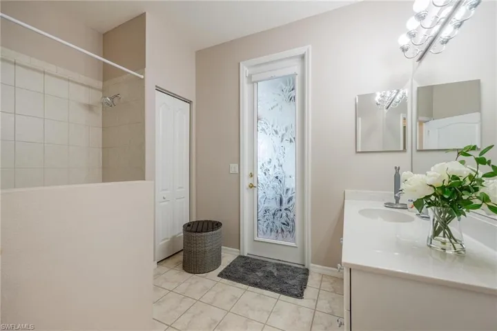 Bathroom featuring tile floors, vanity, and lighting