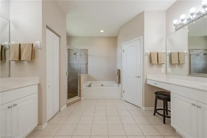Bathroom featuring tile floors, separate shower and tub, and vanity